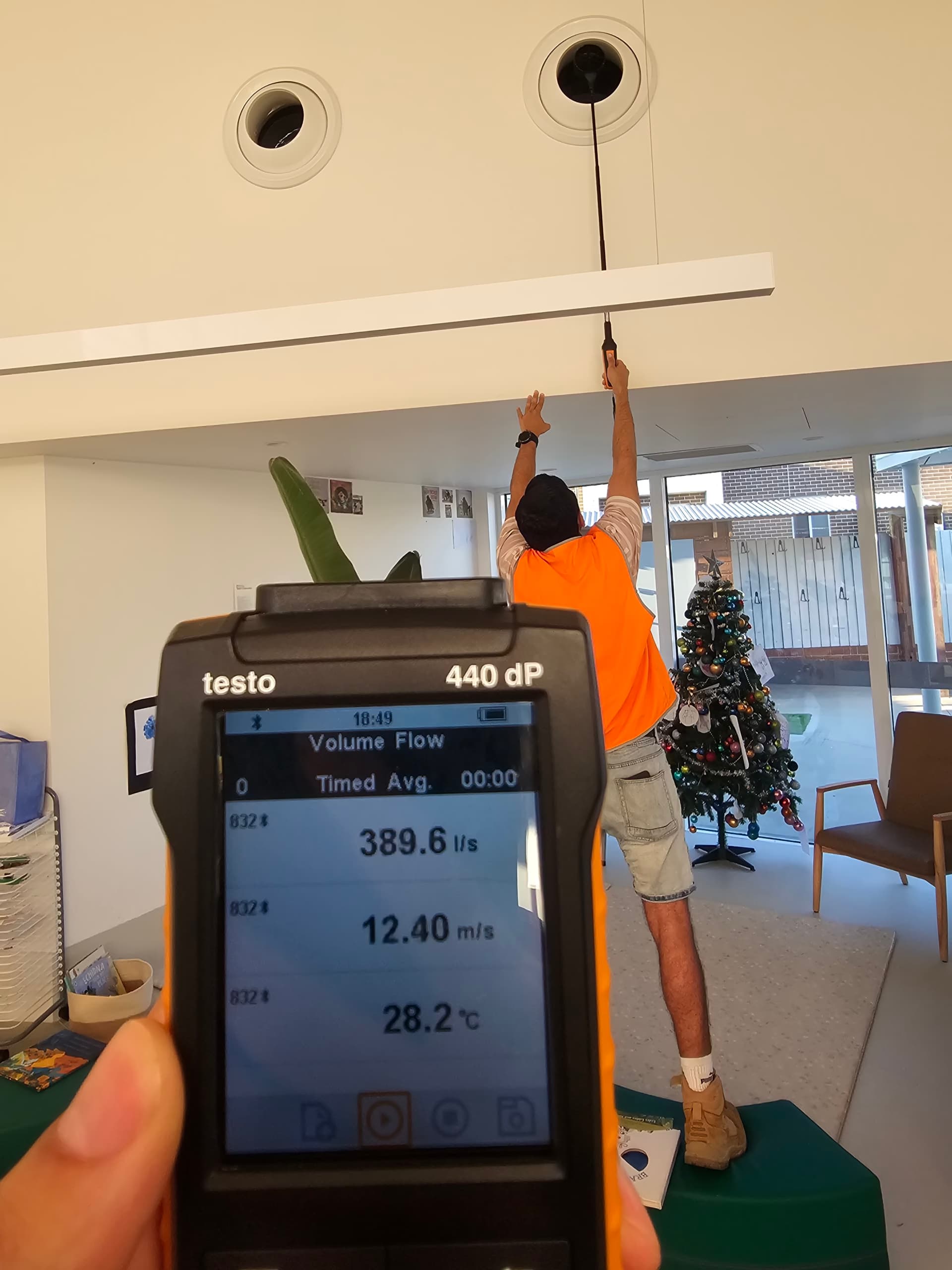 ENGIC technician testing exhaust airflow with a Testo 440dP at a childcare centre in Sydney
