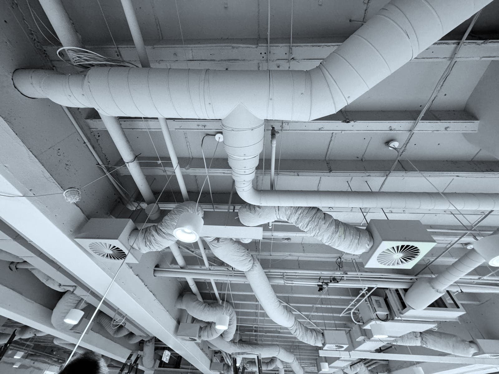 Overhead HVAC ductwork and diffusers in a commercial ceiling space